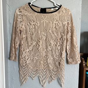 Beautiful, blush colored lace top, with black trim around neckline.